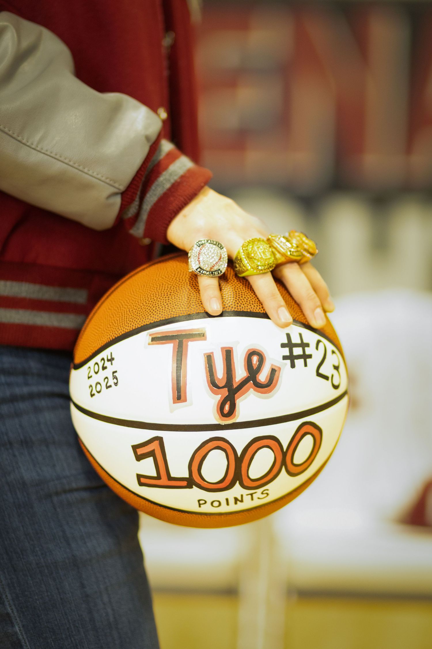 A basketball with text and numbers being written on its white surface shows progressive scoring points in sequence.