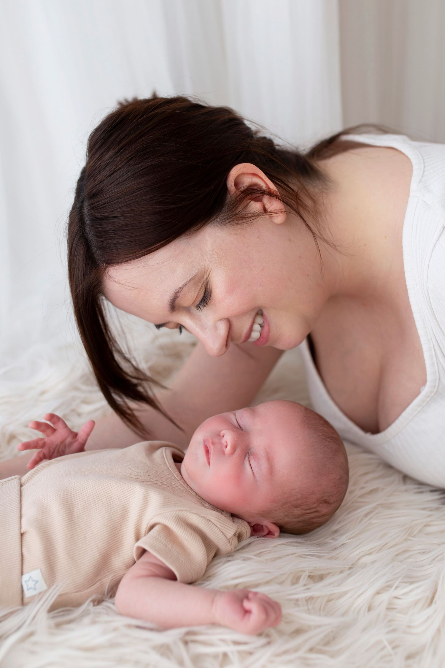 Mother looking at newborn baby smiling by Little Wonderland Photography Widnes Cheshire