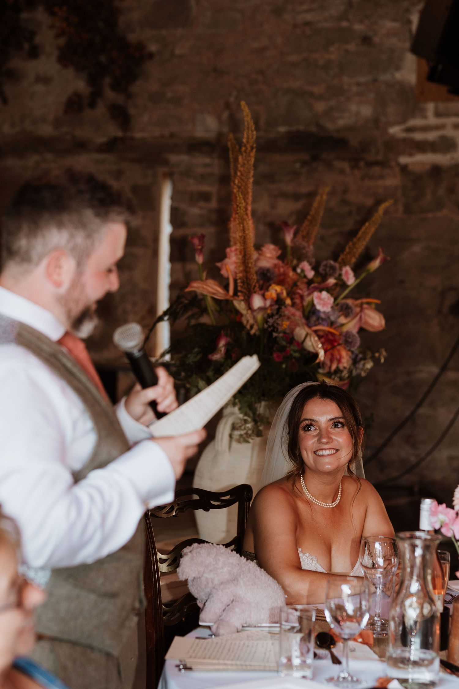 Wedding reception venue decorated with soft string lights and tables set for celebration with guests seated around tables at Lyde Court