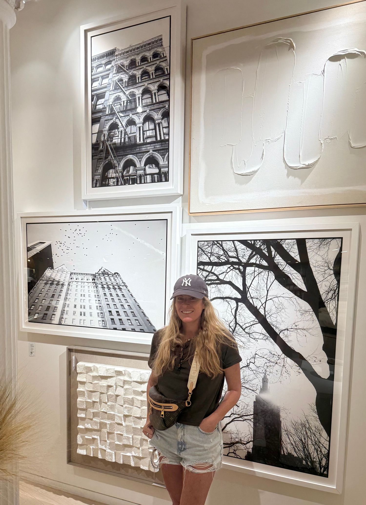 Black and white gallery wall displays architectural photographs and artwork alongside tree silhouette designs.