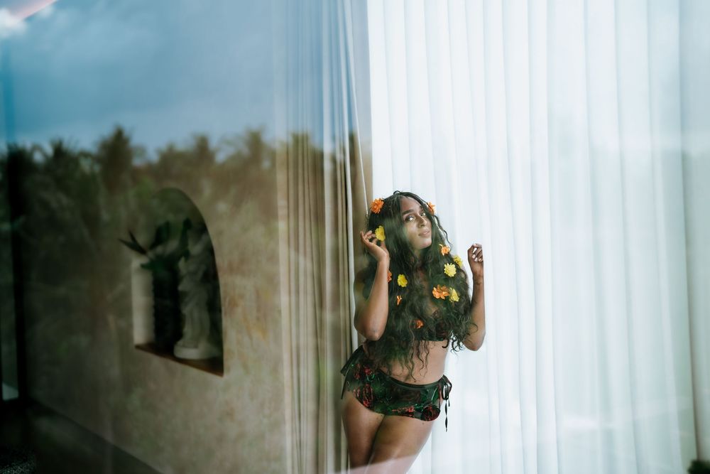 Dreamy window portrait with shadow reflection and yellow flowers in hair.