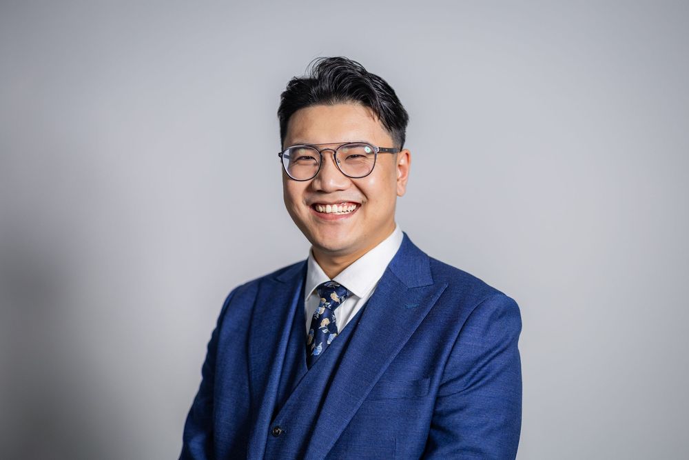 Professional LinkedIn headshot of a guy in a suit smiling at UIUC