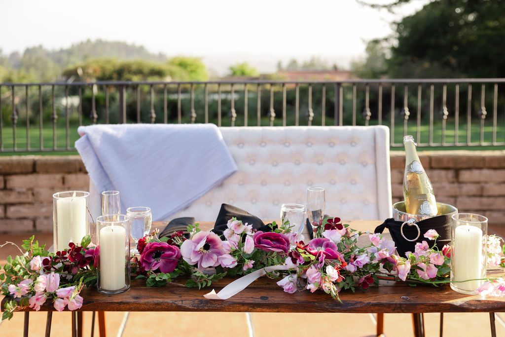 A beautifully decorated wedding tablescape features floral centerpieces and elegant place settings on white linens.