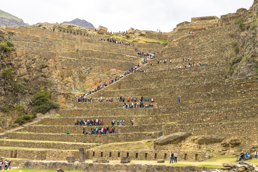 A panoramic view of ancient stone terraces and stairs at Ollantaytambo ruins in Peru's Sacred Valley.