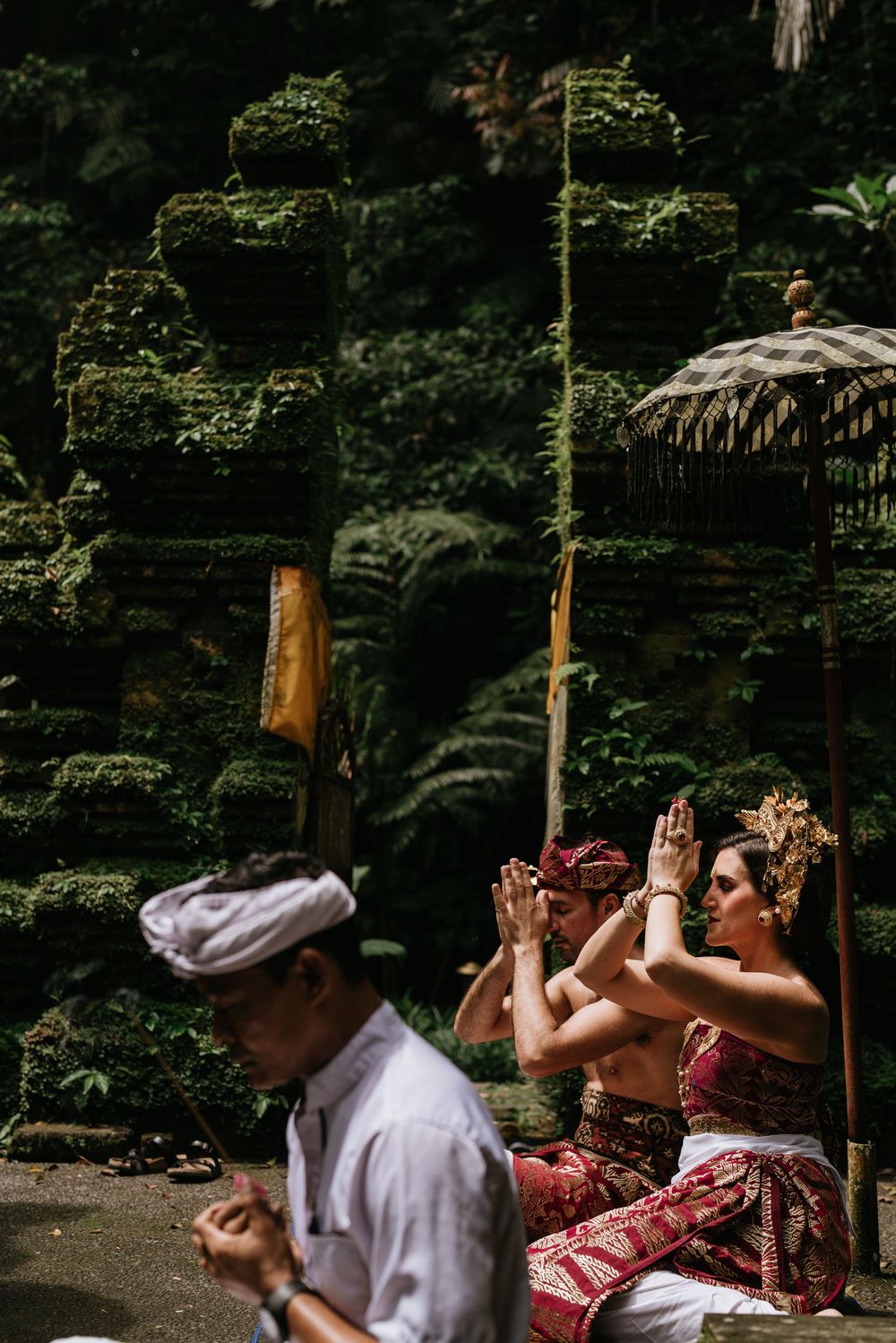 Candid moments captured during a traditional Balinese photoshoot in a serene garden setting.