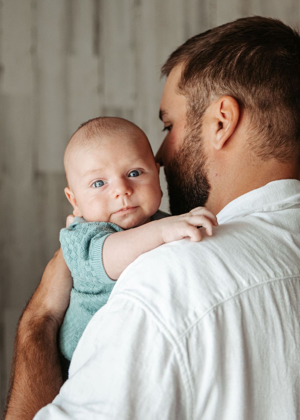 Intimate series of moments between parent and baby wrapped in teal towel.