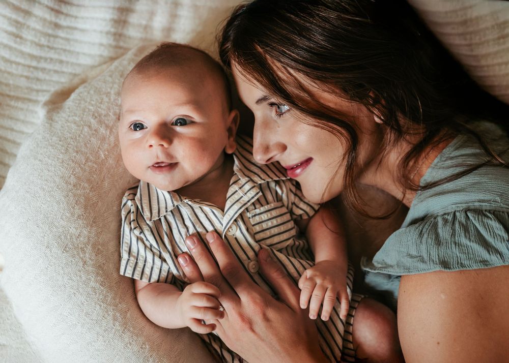 Series of intimate candid photographs showing tender family moments on light colored bedding.