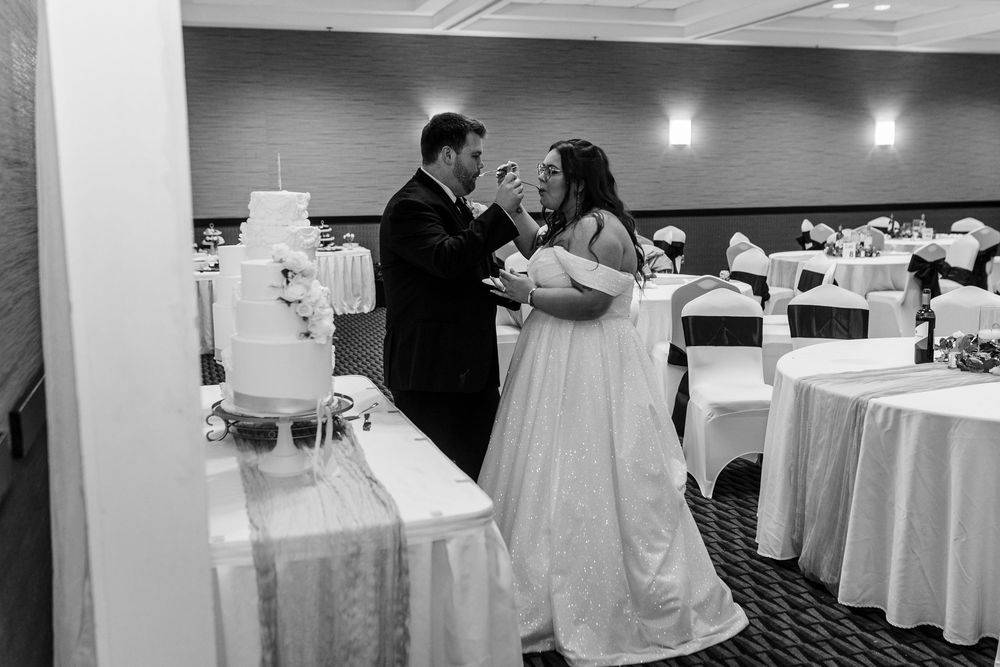 Wedding reception venue decorated with white table linens and centerpieces in a banquet hall.