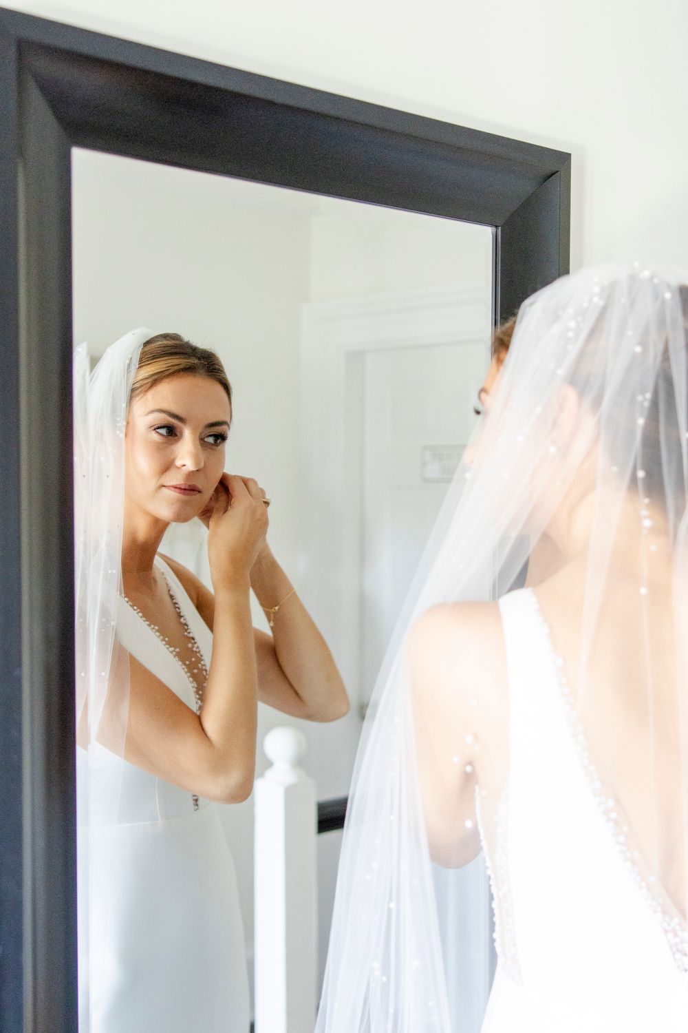 Bride putting in earrings at a luxury Dripping Springs Texas Wedding.