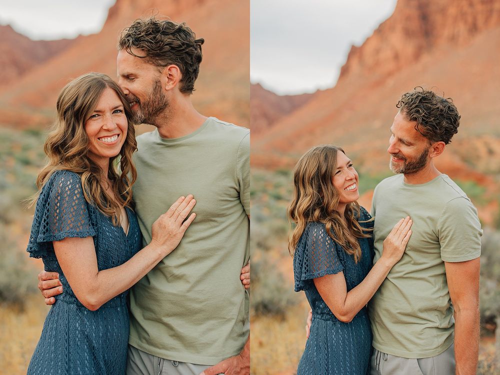 Couple embracing and laughing together in front of red rock formations in a desert landscape.