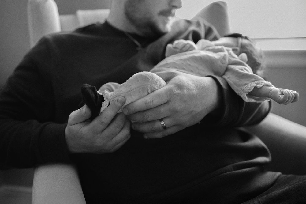 Black and white photo of a father holding a newborn baby