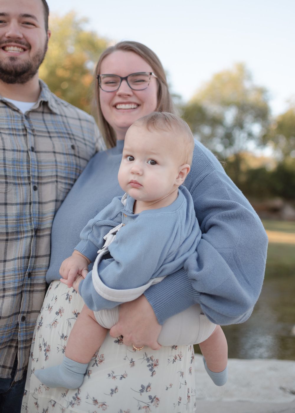 Young family with baby boy smiling during family photos at Nolan Creek Trail in Temple Texas