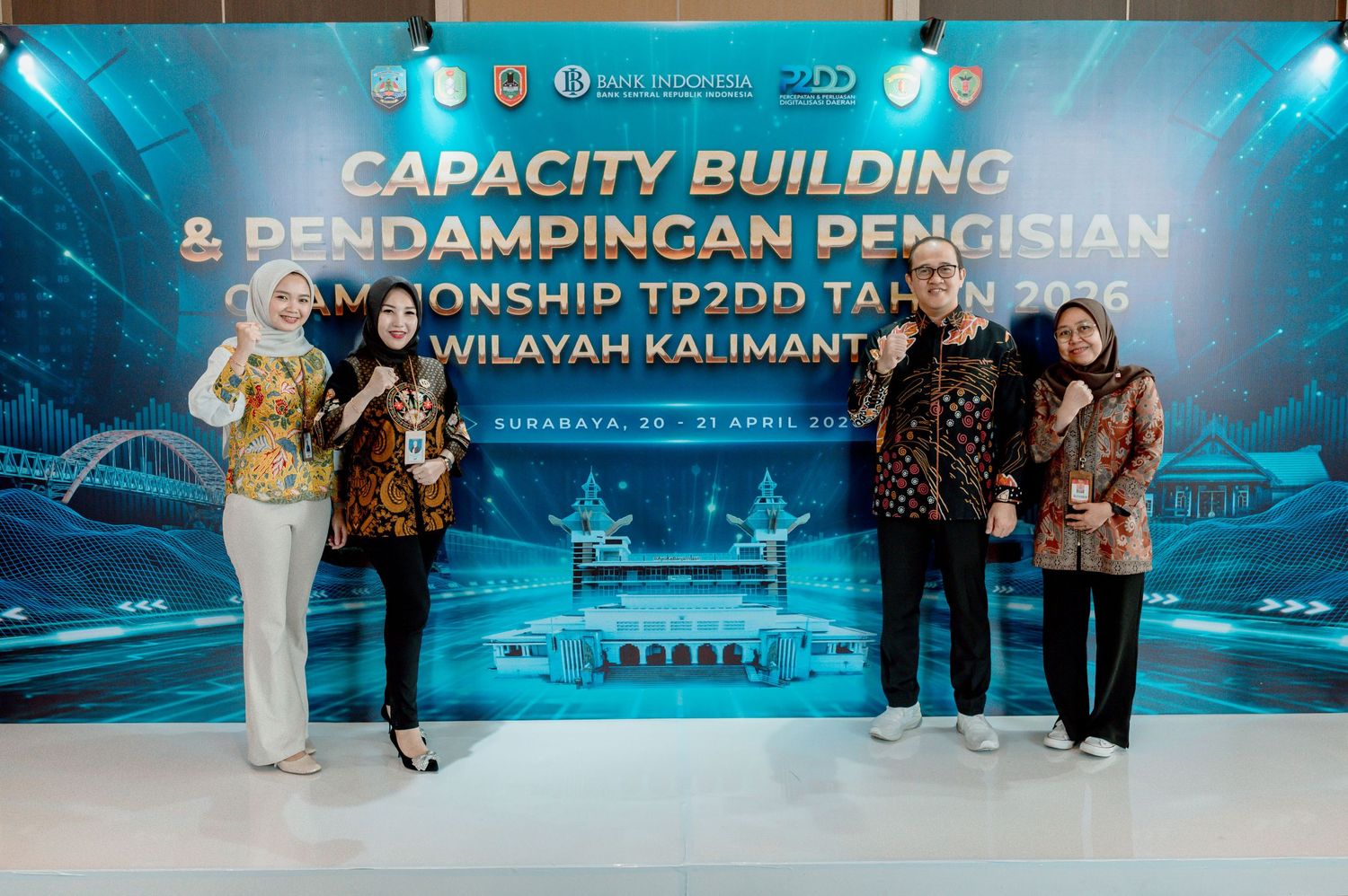 Four professionals pose at Capacity Building TP2DD 2025 event in Kalimantan, hosted by Bank Indonesia, in batik attire.