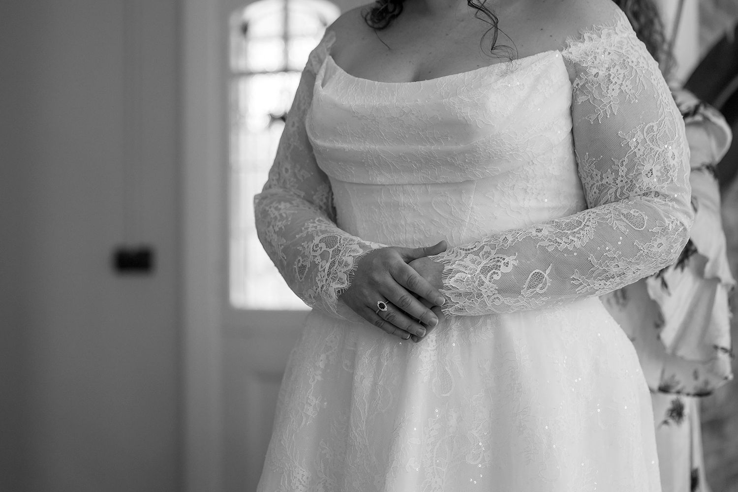 A  black and white wedding image showing dress details and getting ready moments in an elegant room during a brides wedding preparations.
