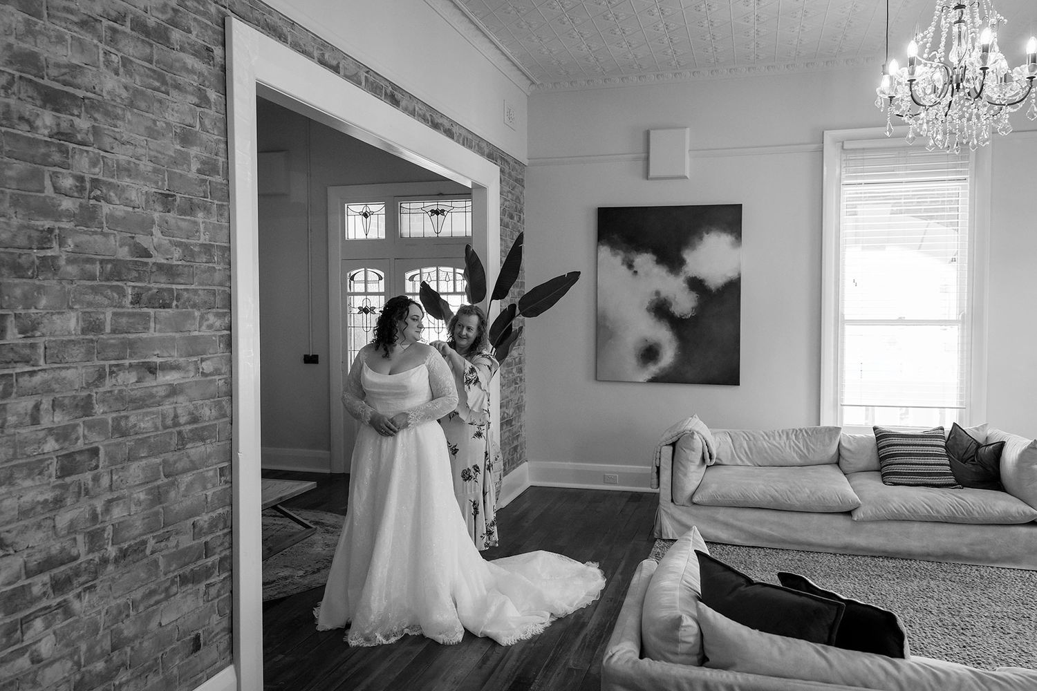 A  black and white wedding image showing dress details and getting ready moments in an elegant room during a brides wedding preparations.