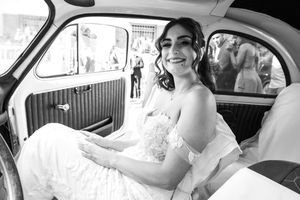 Classic car interior with wedding dress details visible through window.