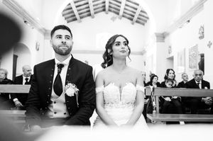 Black and white wedding ceremony photos inside a traditional church setting.