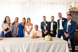 Wedding party and guests gathered in an elegant white reception tent.
