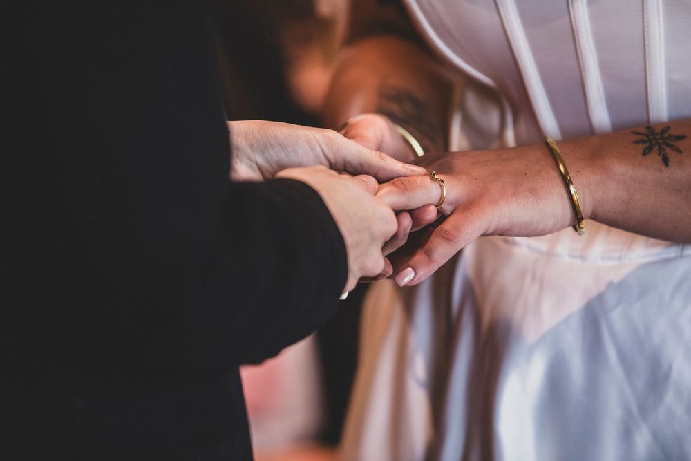 Close-up of hands exchanging wedding rings during an intimate ceremony.