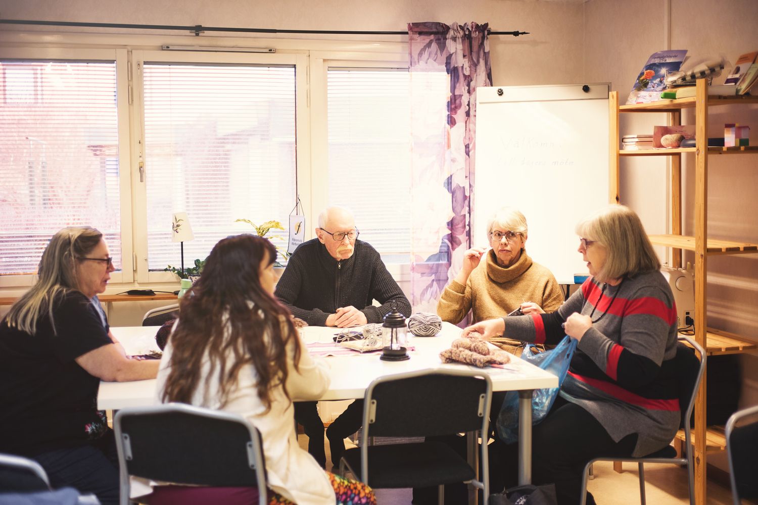 Students seated at long tables in a classroom environment during a study or work session.