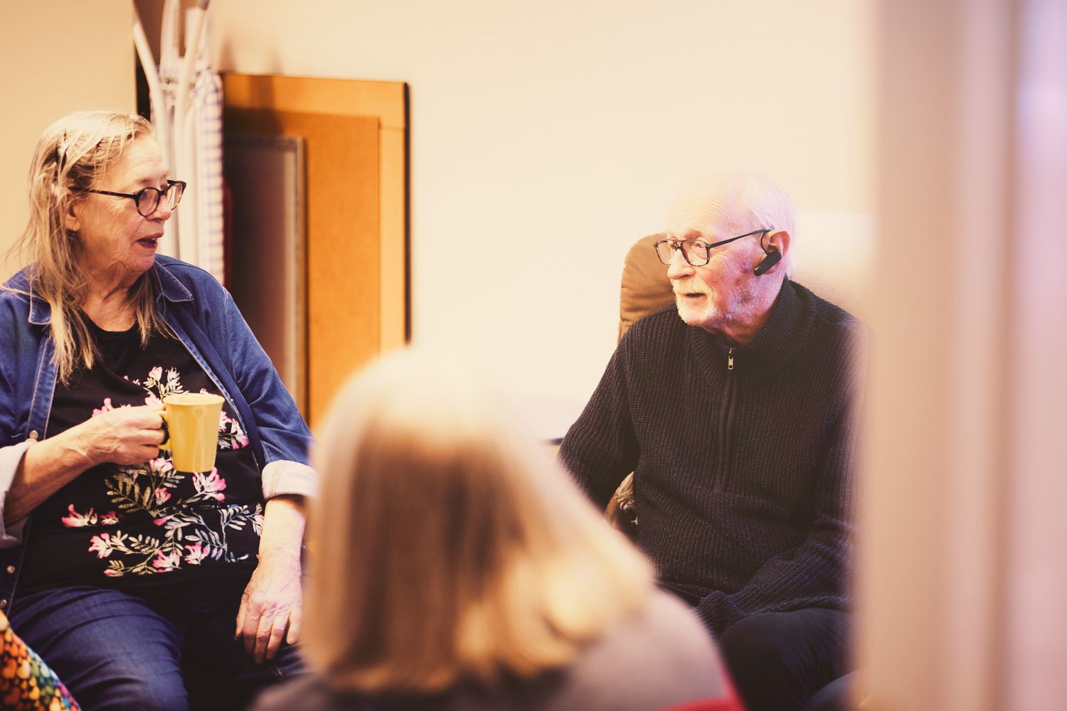 Group of people sitting together in a casual indoor setting having a conversation.