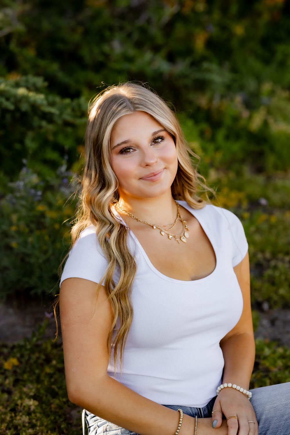 Portrait session in natural outdoor setting wearing white top and casual style.
