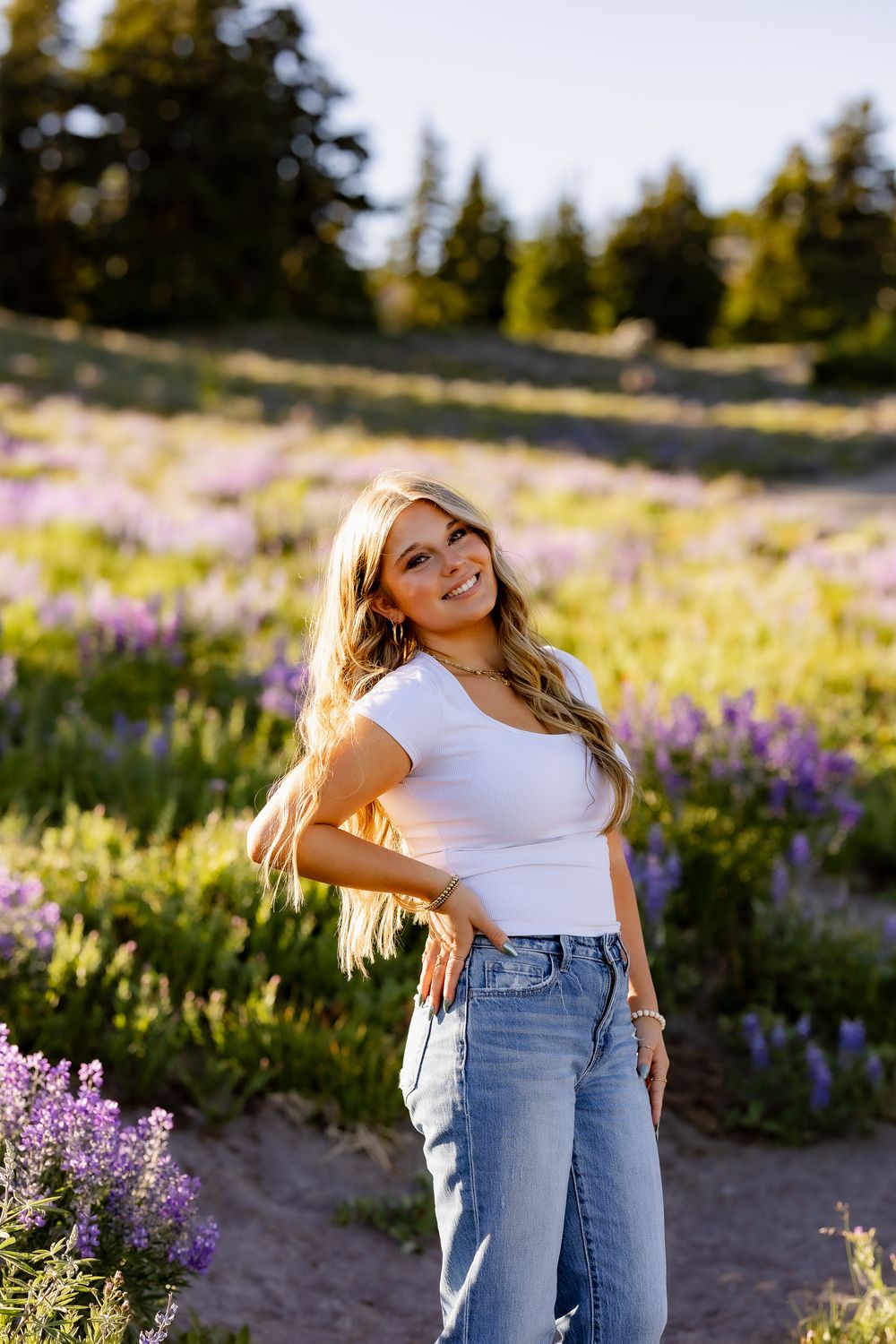 Casual fashion photography in mountain meadow with blooming wildflowers.