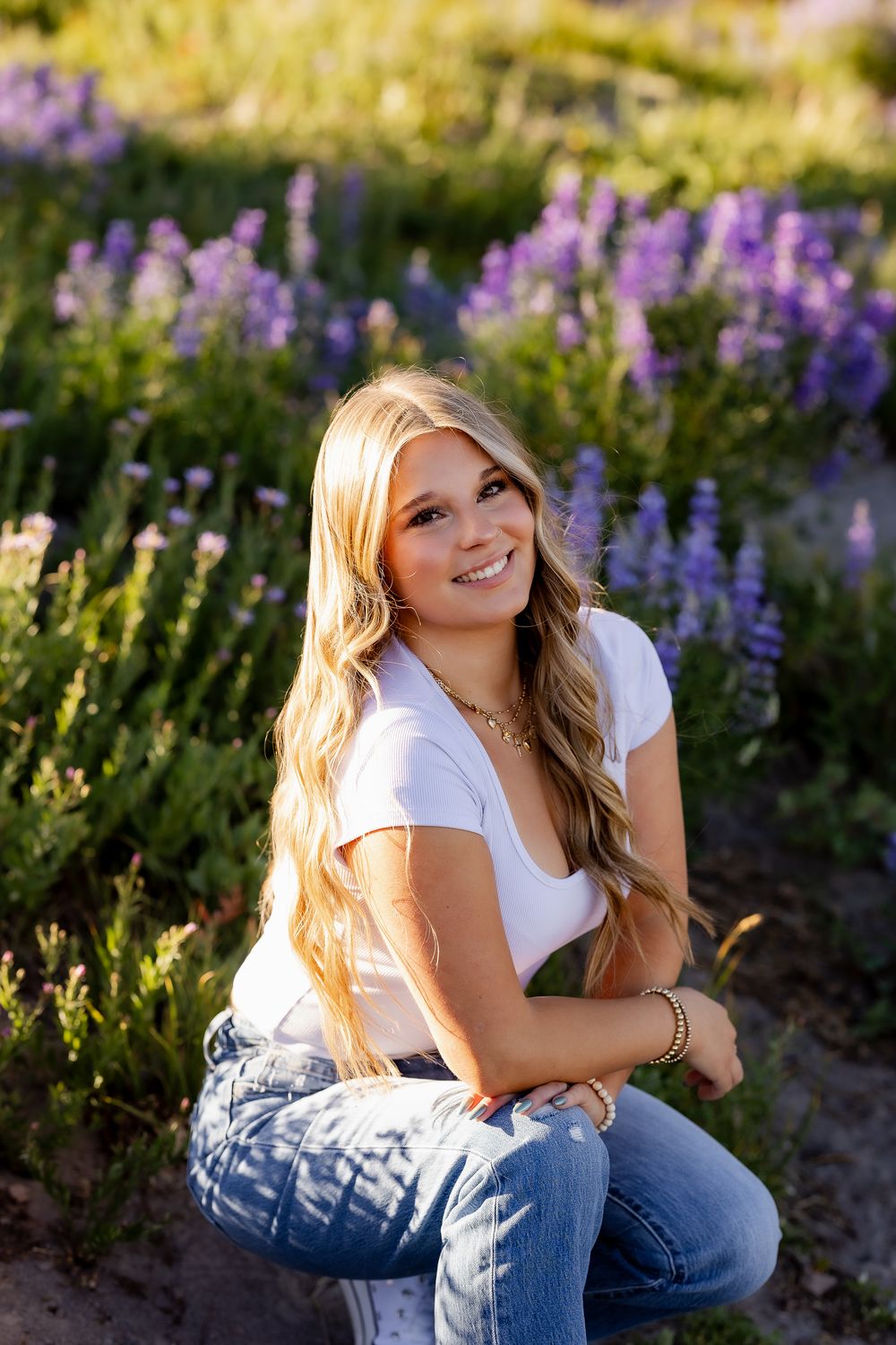 Relaxed outdoor portraits among purple lupine flowers in natural setting.