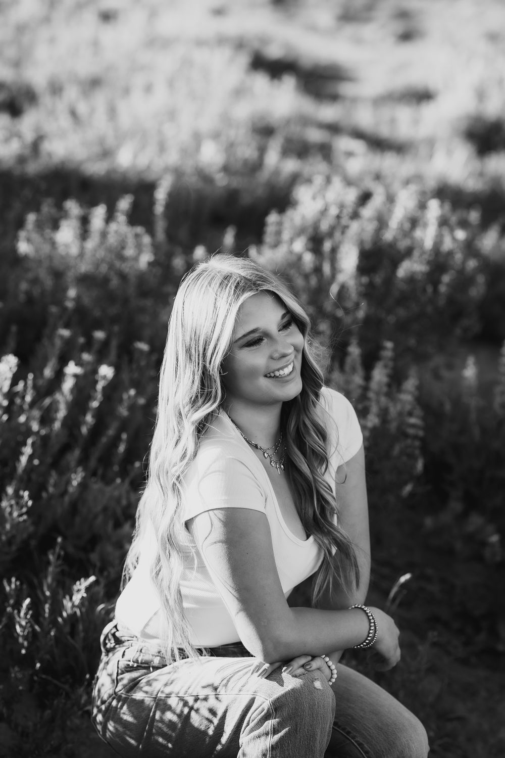 Black and white portrait session in a field of wildflowers during golden hour.
