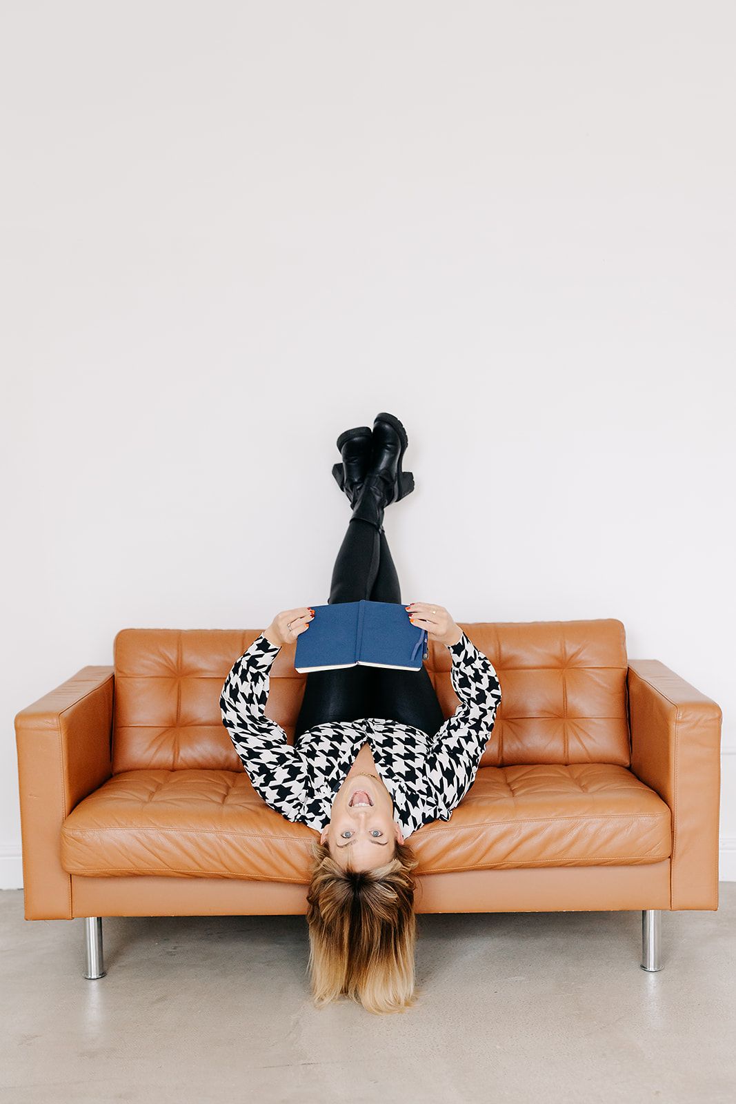 A sequence of four images showing a person in black lying upside down in different positions on a tan leather couch.