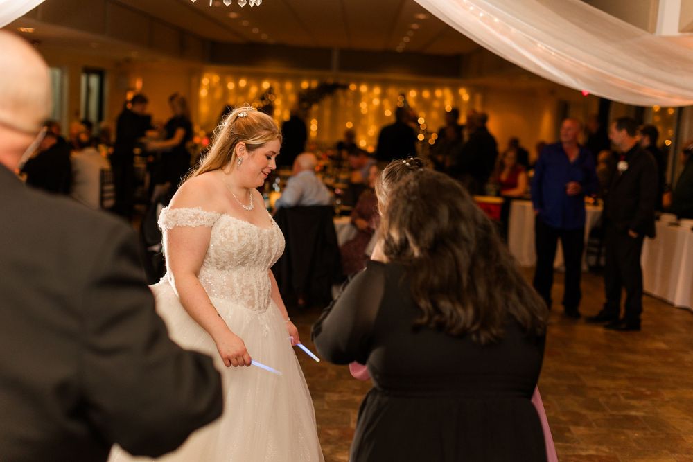 A romantic wedding dance moment captured in a warmly lit reception venue with elegant decor.