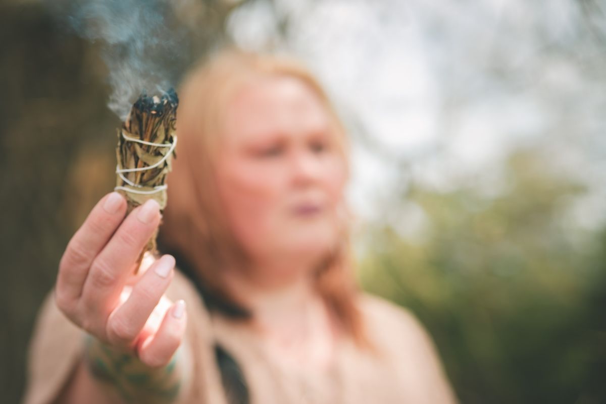healer cleans the air with incense