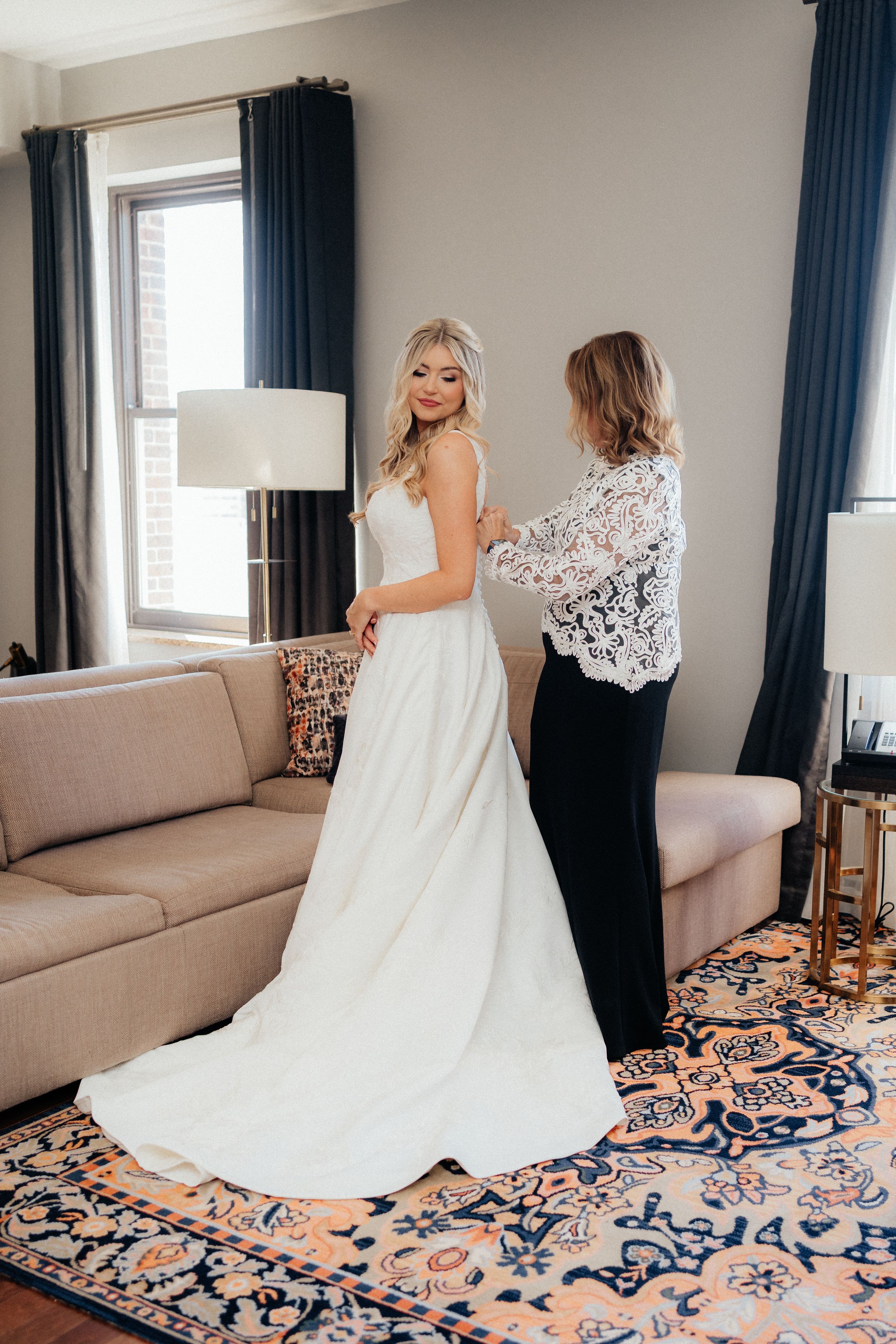 A series showing the first look moment between a couple in a room with blue curtains.