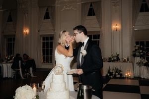 Wedding reception celebration in an elegant ballroom with crystal chandeliers and classic decor.