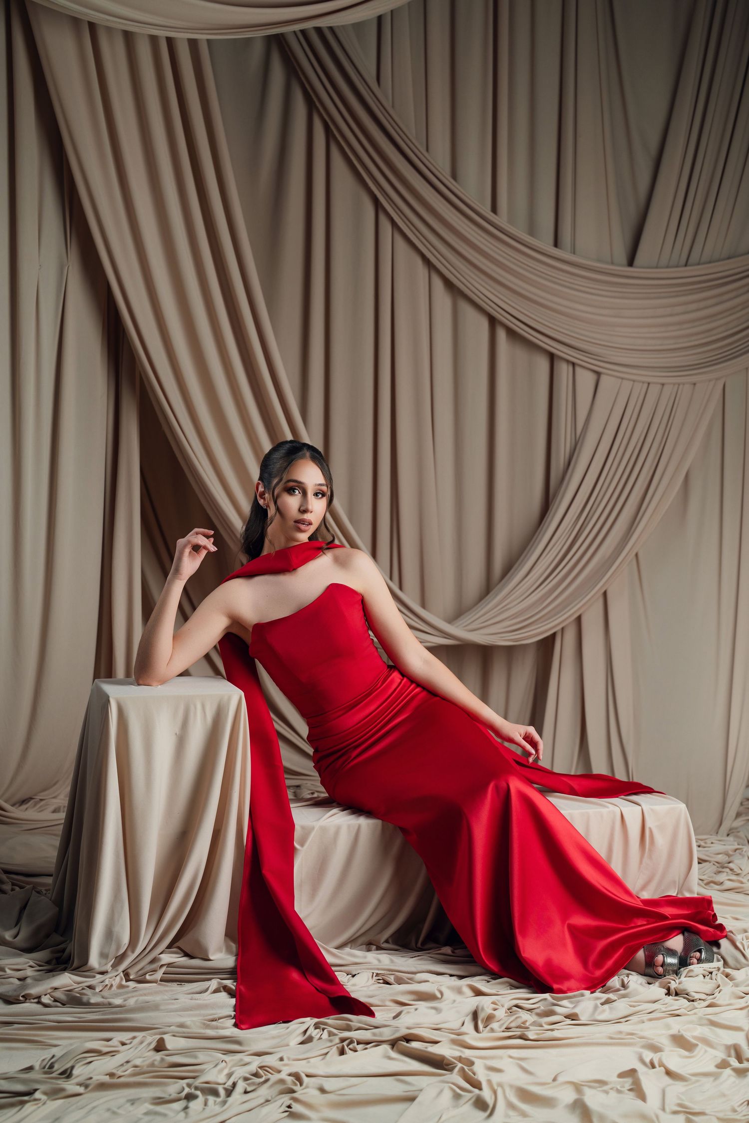 Fashion photo series featuring a red evening gown against draped beige fabric backdrop.