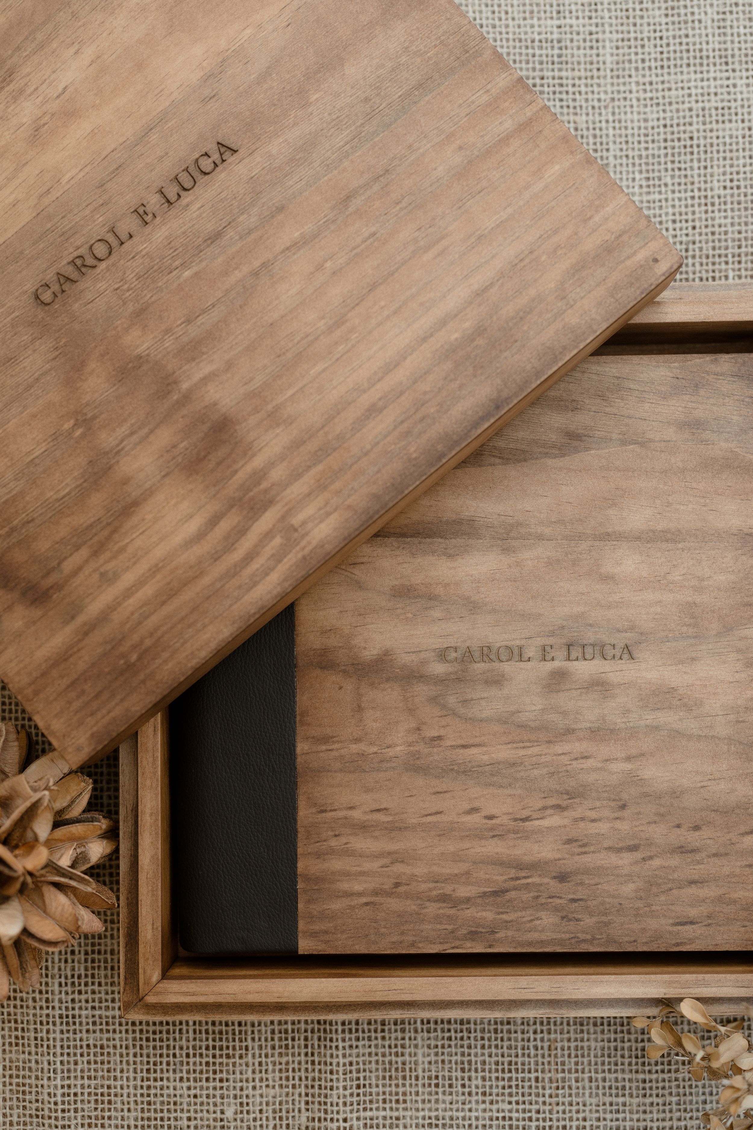 Wooden USB drive boxes with custom branding arranged in a diagonal pattern on a textured linen background.