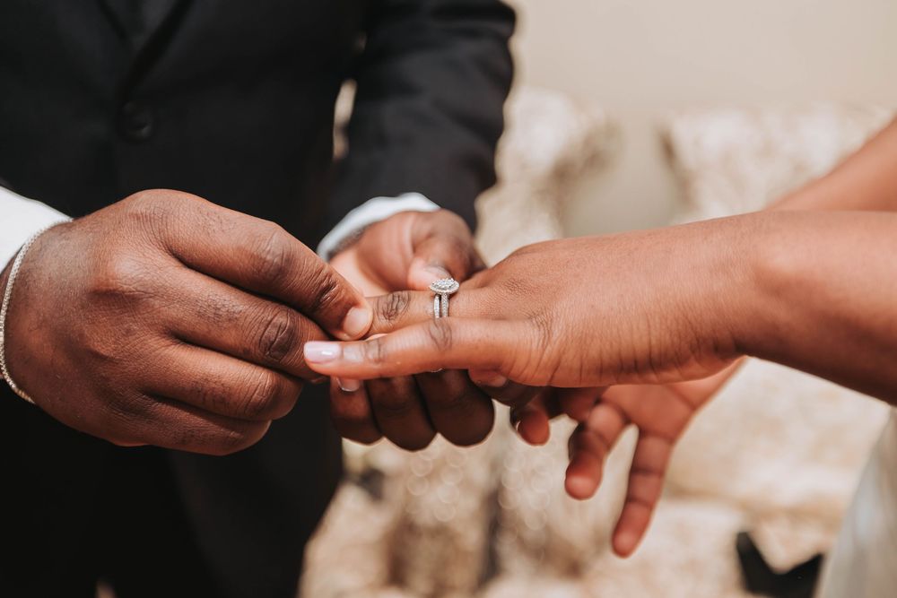 Close-up view of hands exchanging wedding rings during a ceremony ceremony.