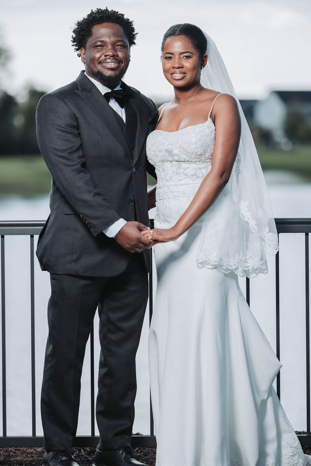 A bride and groom share a tender moment together on a balcony overlooking a scenic landscape.