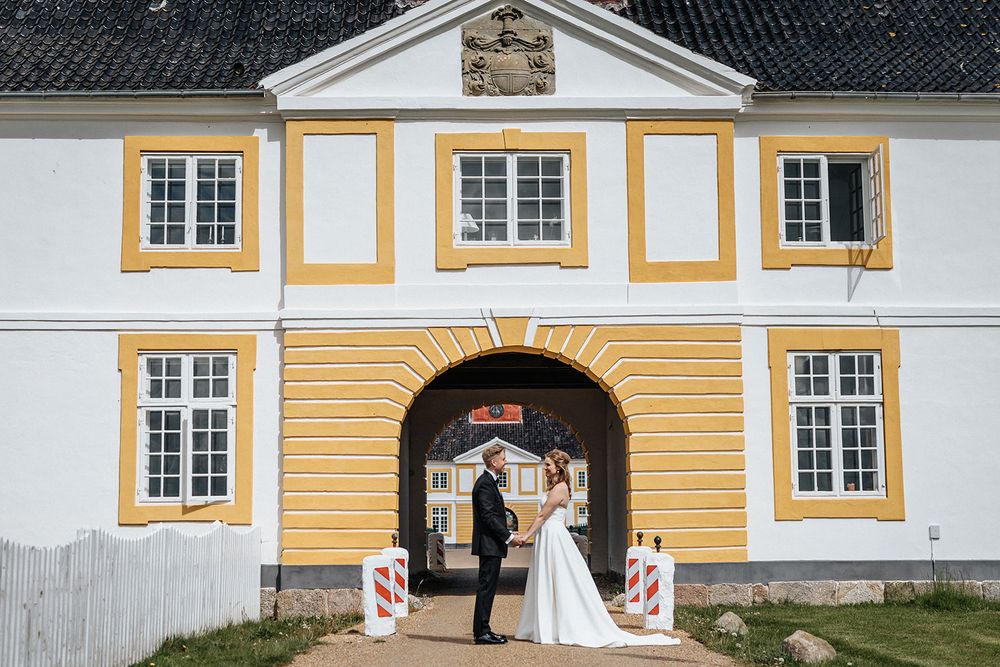 Yellow and white baroque style building facade with symmetrical windows and decorative architectural details.