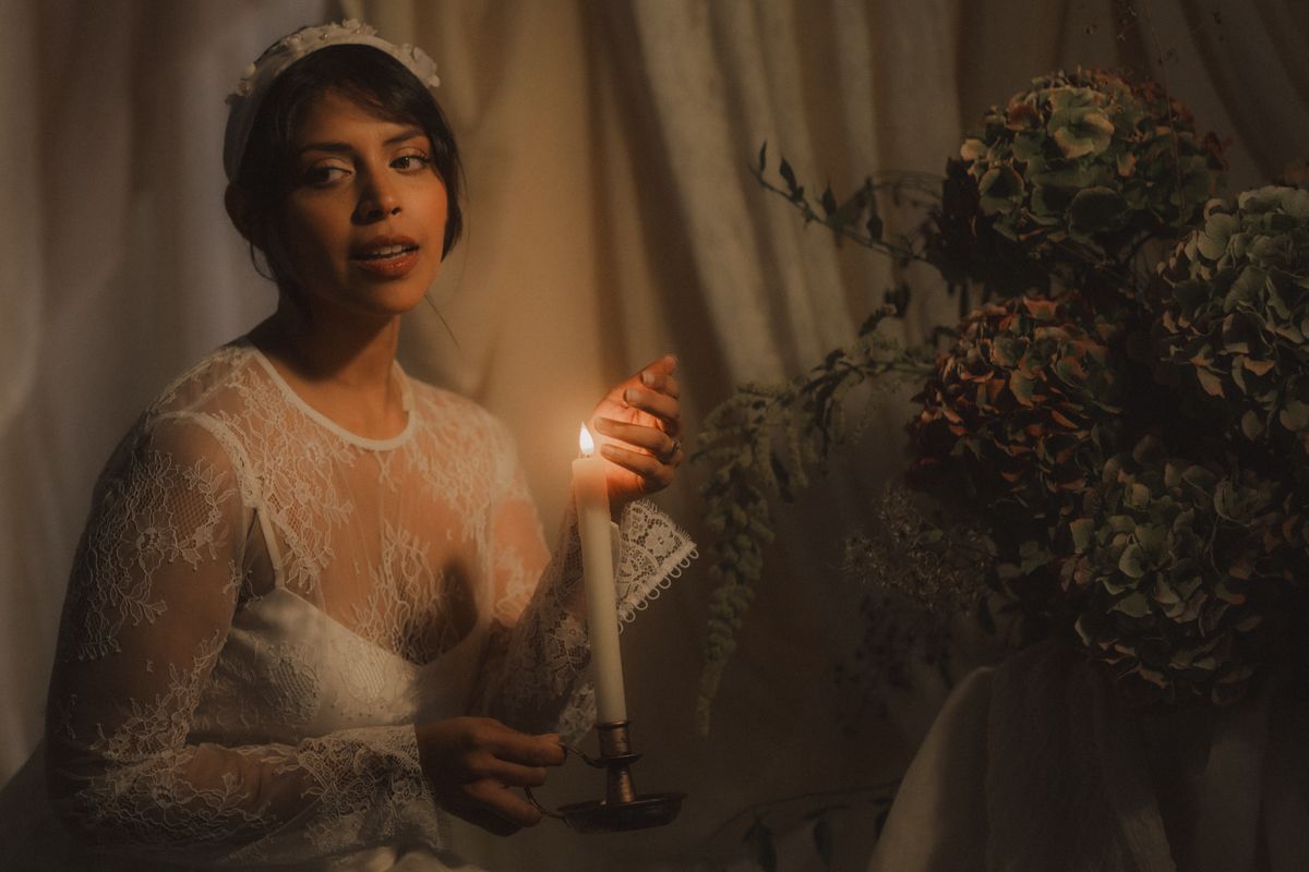 A romantic candlelit scene with lace details and soft lighting creates an intimate wedding atmosphere.