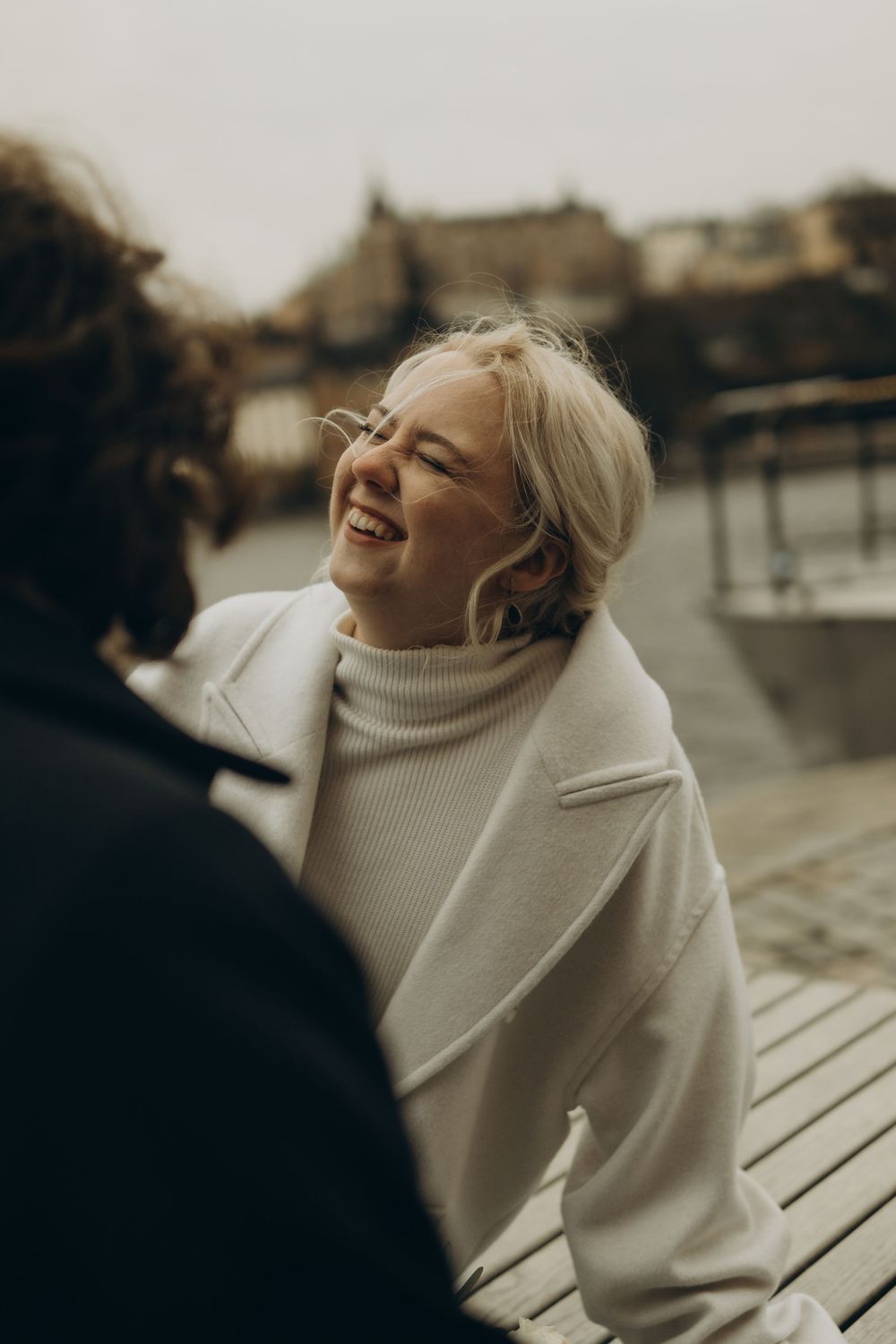 en kvinna skratar med sin man medan de fotas av Stadshuset bröllopsfotograf i Stockholm