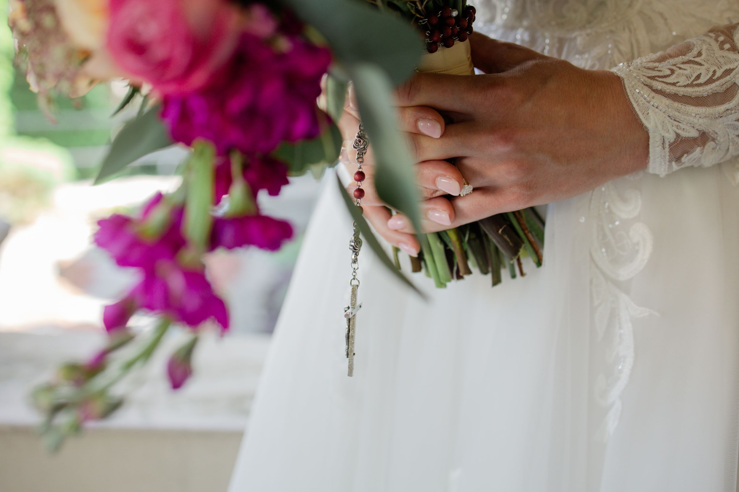 A close-up view of pink and purple orchid bouquets being arranged with delicate white lace details.