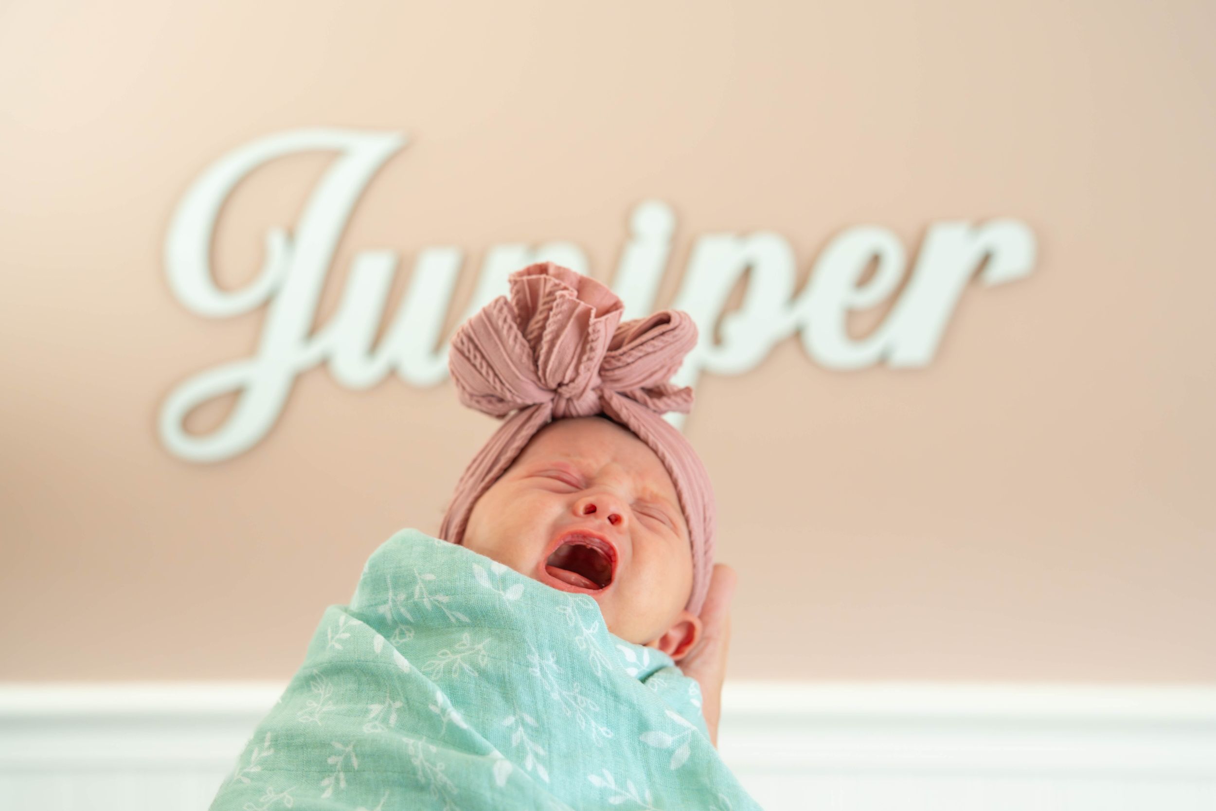 Close-up shots showing gentle kisses and cuddles with a baby against a light beige background.