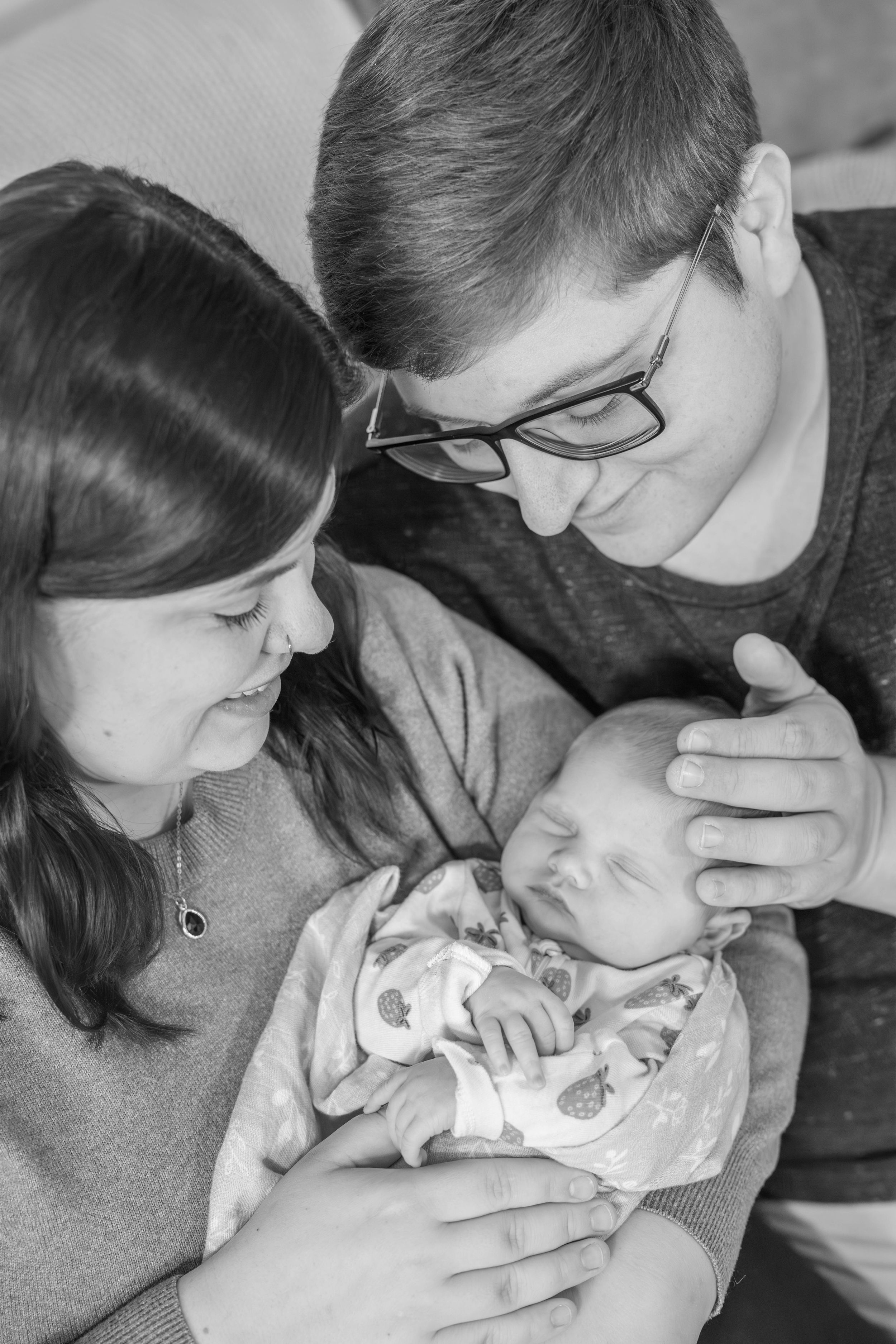 Black and white photos capture intimate bonding moments between parent and infant.