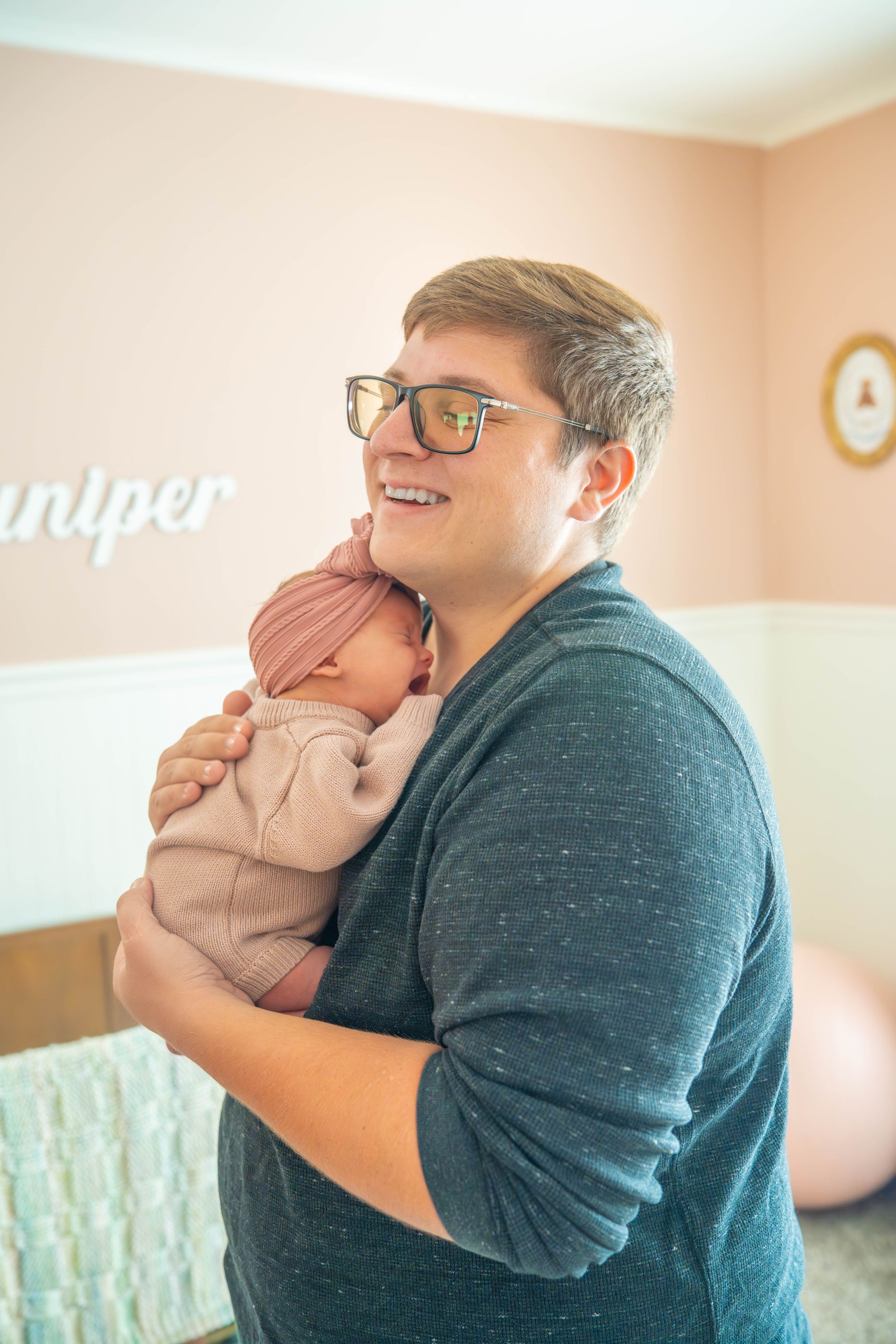 A series of tender moments showing affectionate interaction with a baby in a soft pink-walled room.