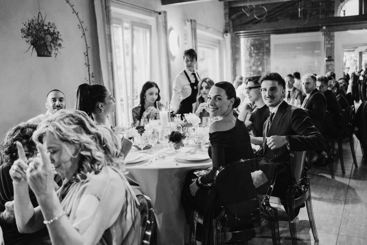 Guests seated at elegantly decorated tables during a wedding reception in a classic venue.