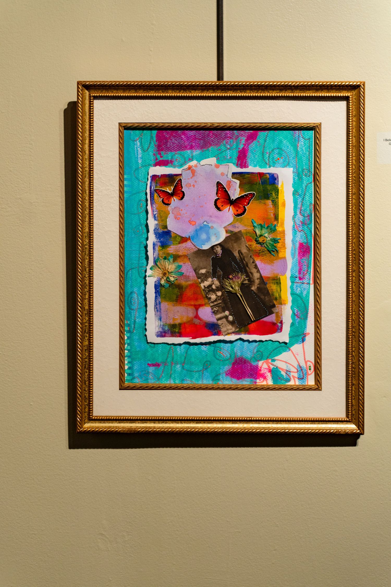 Abstract mixed media artwork in turquoise and pink tones displayed in ornate gold frame.