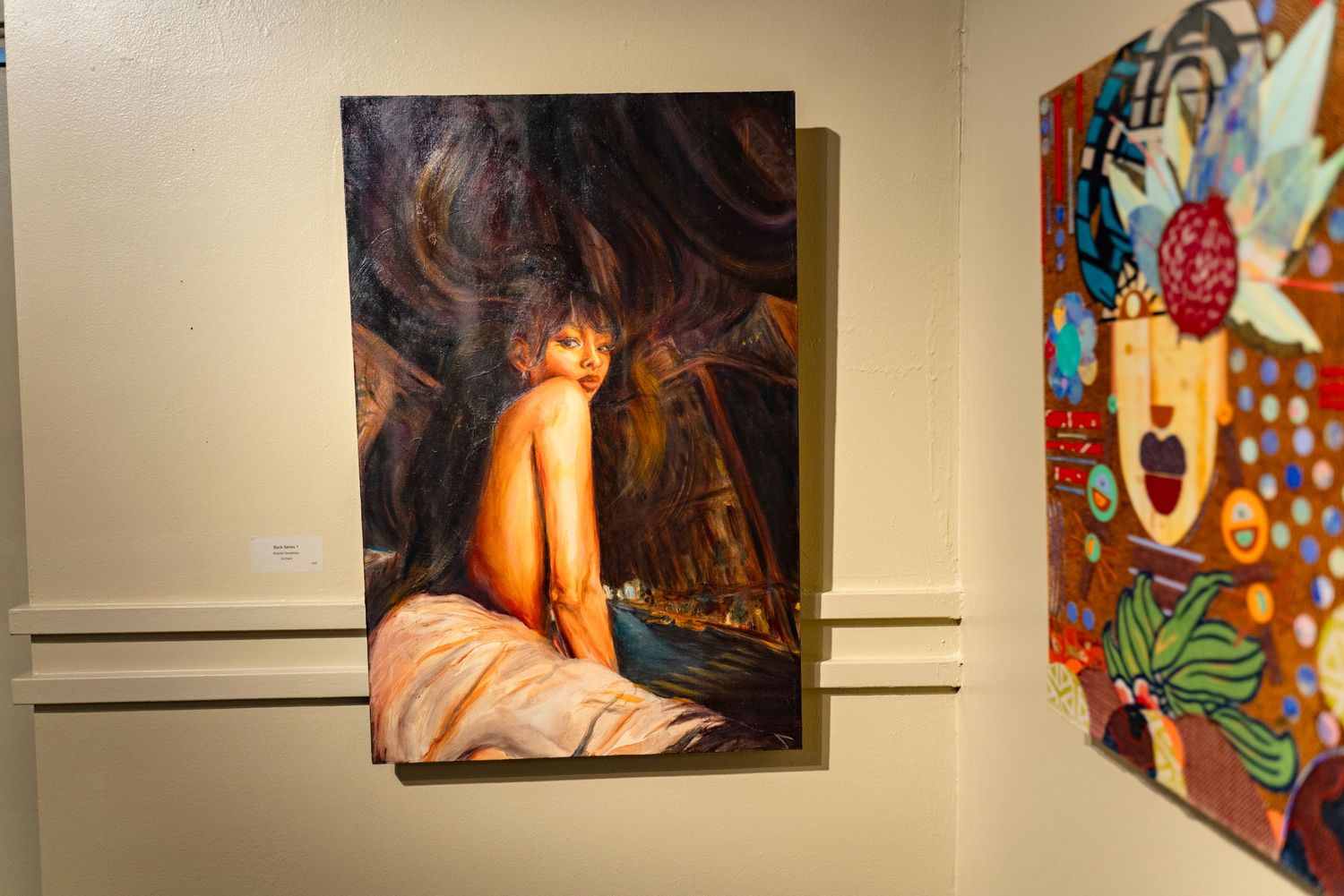 Art gallery wall showing painting with dark swirling background patterns.