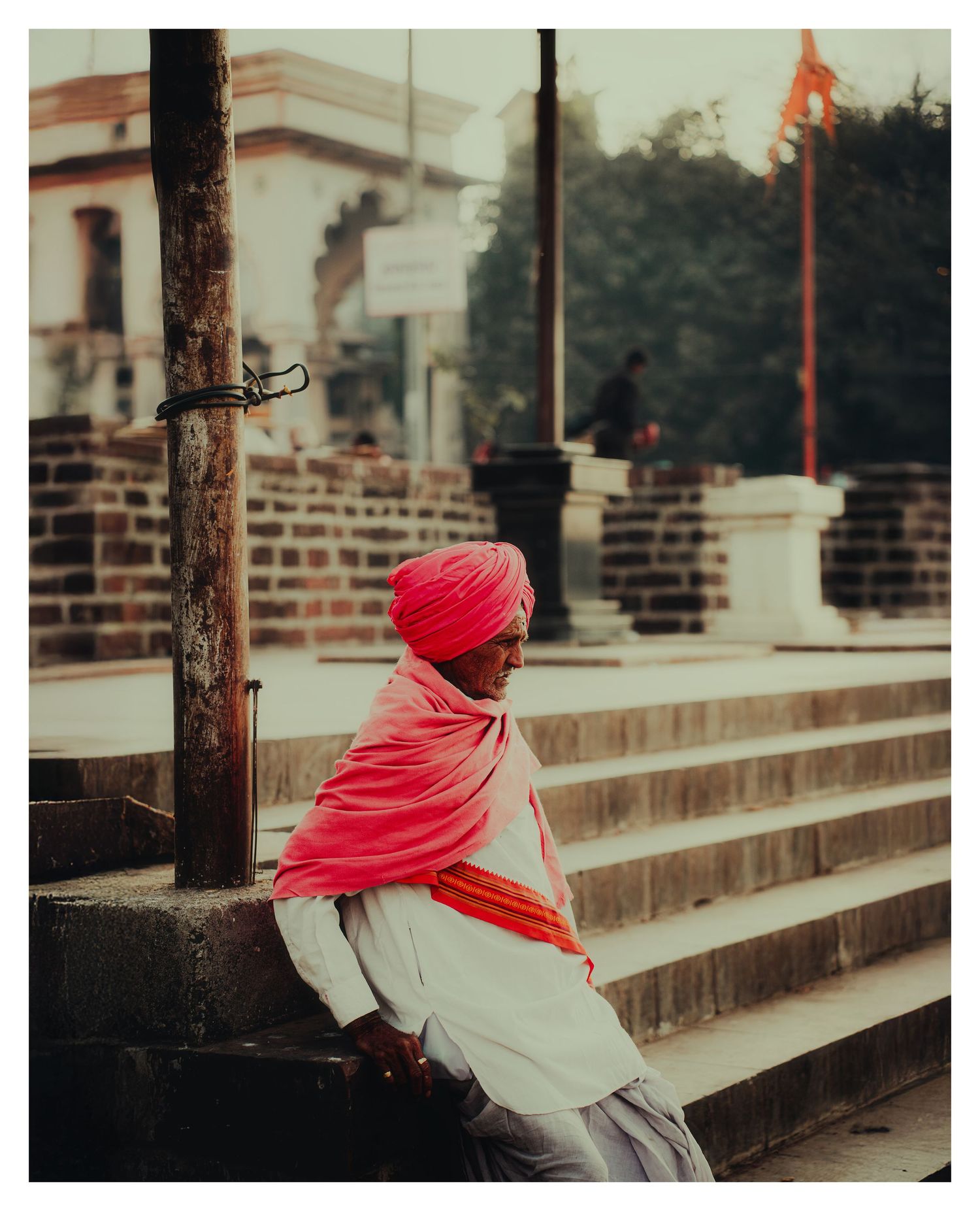 Person wearing a bright red scarf sits on concrete steps in an artistic photo sequence.