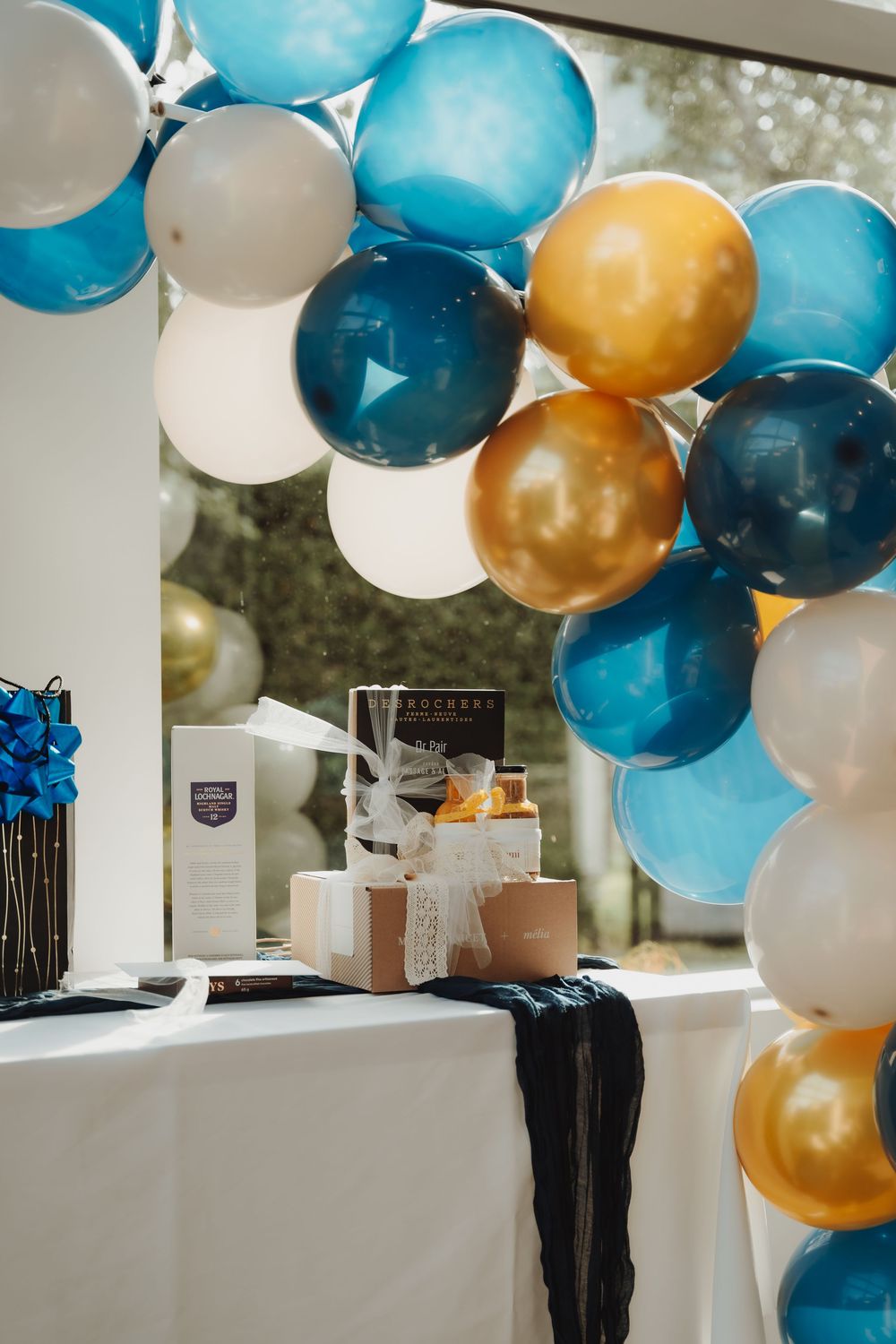 Photographie d'un 50e anniversaire surprise à la Cidrerie Lacroix avec des ballons et des cadeaux.
